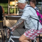 Тату с цветами и листвой на руках колоритного деда на велосипеде - Уличная тату (street tattoo) № 14–210821 2
