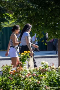 Фотография двух женщин, идущих по улице. У одной из них видна татуировка на руке.