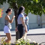Фотография двух женщин, идущих по улице. У одной из них видна татуировка на руке.