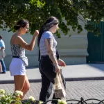 Фотография двух женщин, идущих по улице. У одной из них видна татуировка на руке.