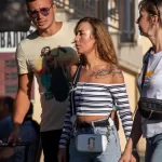 Фотография мужчины и женщины, идущих по улице. У мужчины татуировка на плече, у женщины - татуировка с цветами на руке.