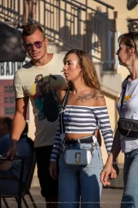 Фотография мужчины и женщины, идущих по улице. У мужчины татуировка на плече, у женщины - татуировка с цветами на руке.
