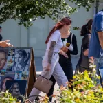 Фото тату: реалистичный портрет мужчины, украшенный цветами, на руке девушки. Идеально для тех, кто ищет идеи для тату в стиле реализм.