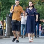 Фотография мужчины и женщины, идущих по улице. У мужчины видны татуировки на руках и ногах, выполненные в черном цвете.