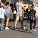 Фотография мужчины с татуировкой на ноге, идущего по улице. Татуировка выполнена в темных тонах и видна на икре.
