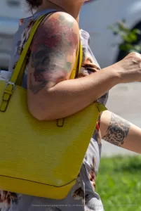 Фото тату на плече женщины: красочный рисунок с элементами портрета и абстрактными мазками, выполненный в смешанной технике.