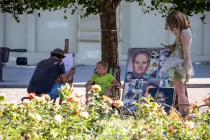 Фото тату: Уличный художник рисует эскизы татуировок для клиентов на открытом воздухе. Разнообразие рисунков, портреты и символы.