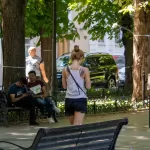 Фото тату на спине девушки, демонстрирующее красивый цветочный рисунок в черных тонах. Татуировка выполнена в стиле графика и выглядит очень нежно.