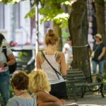 Фото тату на шее девушки: изящный цветочный рисунок, выполненный в черных тонах, с использованием тонких линий.