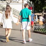 Фото тату ворона на предплечье мужчины. Черный ворон в полете с красными брызгами краски, детальная проработка перьев, динамичная композиция.