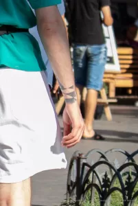 Фото тату на запястье мужчины. Рисунок татуировки представляет собой абстрактный узор в минималистичном стиле.