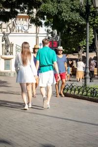 Фото тату на запястье мужчины, идущего с девушкой. Рисунок татуировки представляет собой абстрактный узор в минималистичном стиле.