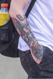 Фото тату на руке мужчины: красочный рисунок с изображением змеи, игральных костей, цветов и других элементов. Идеи для татуировки в стиле олдскул.