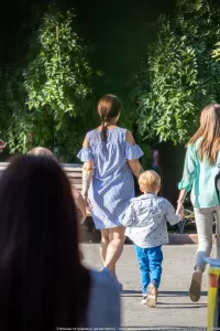 Фото тату: татуировка на спине женщины с изображением цветов и листьев, выполненная в акварельной технике.