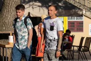 Фото тату: татуировка на руке с изображением волн и рыб, выполненная в черно-белой графике.