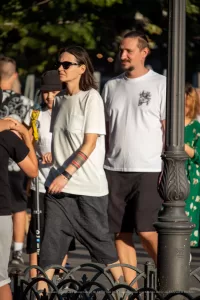 Фотография женщины с татуировкой на предплечье, выполненной в ярких цветах, и мужчины с татуировкой на плече.