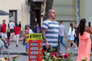 Фото тату на руке мужчины в полосатой футболке. Рукав татуировки с изображением дракона, черепа и цветов в японском стиле.