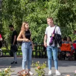 Фотография девушки и молодого человека с татуировками, стоящих на улице. Современный стиль, городская среда, повседневная одежда. Детализированное фото тату.