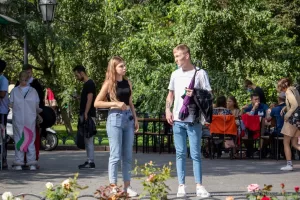 Фотография девушки и молодого человека с татуировками, стоящих на улице. Современный стиль, городская среда, повседневная одежда. Детализированное фото тату.