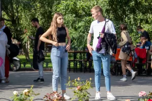 Фотография девушки и молодого человека с татуировками, стоящих на улице. Современный стиль, городская среда, повседневная одежда. Детализированное фото тату.