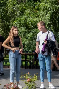 Фотография молодого человека с видимыми татуировками на руках и шее. Современный стиль, городская обстановка, повседневная одежда.