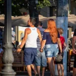 Фото тату: татуировка на спине мужчины, частично видна. Рисунок в темных тонах, демонстрирующий сложный узор и детализацию.