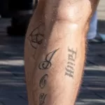 Тату надпись Faith и крест внизу ноги парня — уличная тату (street tattoo) № 15– tatufoto.com 230821 3