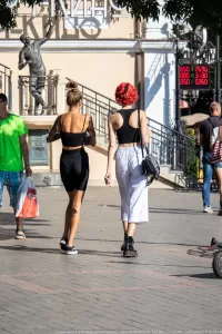 Фото тату: Татуировки на спине и руке девушки, выполненные в уличном стиле, с использованием черных чернил и абстрактных узоров.