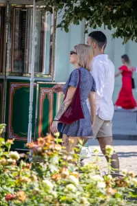 Фото тату на руке и ноге девушки, идущей по улице. Детализированные черно-серые рисунки татуировок в японском и реалистичном стилях.