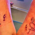 Фото тату: два минималистичных рисунка фламинго и бокала вина на запястьях. Изображения выполнены тонкими линиями, символизируя связь и общие интересы.