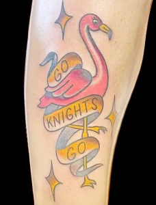 Фото тату фламинго с надписью "Go Knights Go" и звездами на ноге. Яркий и спортивный дизайн татуировки.