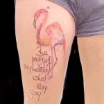 Фото тату фламинго, выполненного в акварельной технике, с надписью "Be yourself no matter what they say".