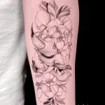 Черно-белое фото тату пиона на предплечье, выполненное в технике лайнарт с тонкими линиями и детальной проработкой лепестков.