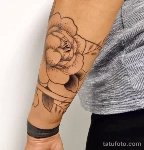 Фото минималистичной татуировки пиона на предплечье, выполненной в технике blackwork с использованием точечной штриховки.