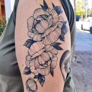Фото тату изящных пионов, выполненных в технике line work на руке. Детализированный рисунок татуировки с акцентом на лепестки и листья.