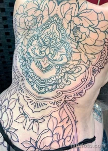 Фото тату: Татуировка на боку с изображением пиона и мандалы в стиле blackwork. Изящные линии и детализированная проработка.