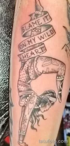 Фото татуировки гимнастки с надписью "Blame it on my wild heart" на руке. Черно-серый рисунок в стиле sketch.