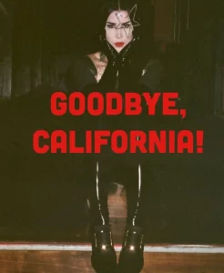Фото: Киану Ривз в темной одежде с надписью "Goodbye, California!". Готический стиль и татуировки.