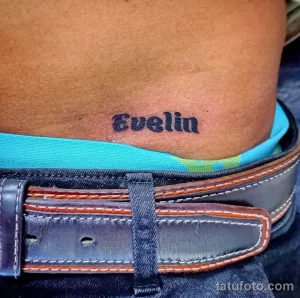 Фото тату: татуировка с именем "Evelin", выполненная простым шрифтом на пояснице. Персонализированный рисунок, символизирующий любовь и память.