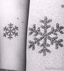 Фото тату: две снежинки, выполненные в технике dotwork (точечная техника), расположены на руке. Минималистичный рисунок татуировки.
