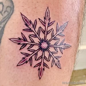 Фото тату: большая снежинка, выполненная в технике blackwork (черная работа), расположена на руке. Детализированный рисунок татуировки.