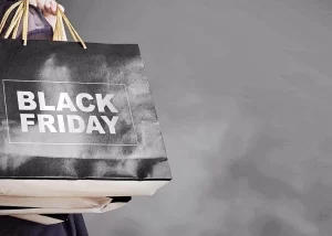 Фото: руки держат черные пакеты с надписью "Black Friday". Акция, распродажа, шопинг.