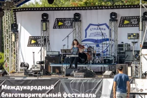 Фото тату: Скрипачка играет на сцене, демонстрируя татуировку на руке. Яркий свет и музыкальная атмосфера.