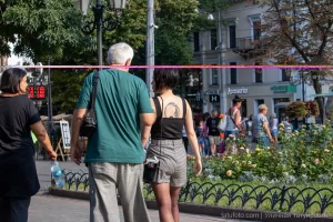 Фото тату на спине девушки, идущей по улице. Черно-белый рисунок татуировки в виде абстрактного узора, выполненный в графическом стиле.