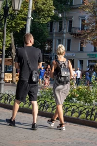 Фото тату на руке и ноге девушки, идущей с молодым человеком. Видны детали рисунков татуировок, выполненных в разных стилях.