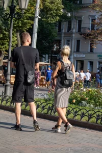 Фото тату на руке и ноге девушки, идущей с молодым человеком. Видны детали рисунков татуировок, выполненных в разных стилях.