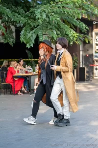 Фотография девушки и парня, одетых в костюмы персонажей аниме, с татуировкой на руке девушки.