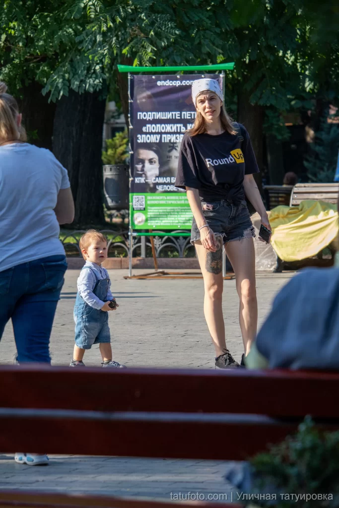 Молодая мама с тату енота из фильма Стражи Галактики на правой ноге 13 - Уличная тату (street tattoo) № 16– tatufoto.com 28082021№0284