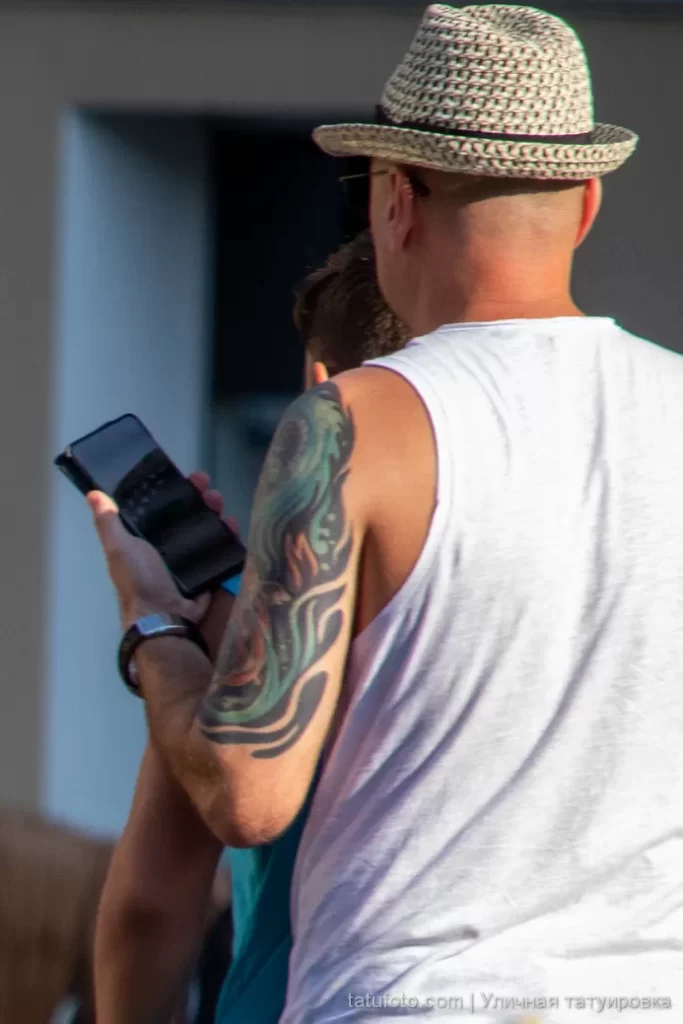 Мужчина с большой цветной татуировкой на левой руке у плеча 2 - Уличная тату (street tattoo) № 16– tatufoto.com 28082021№0313