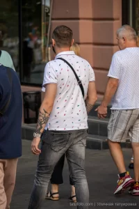 Фото татуировки на руке мужчины: изображение птицы, окруженное абстрактными элементами и узорами. Детализированный рисунок татуировки.